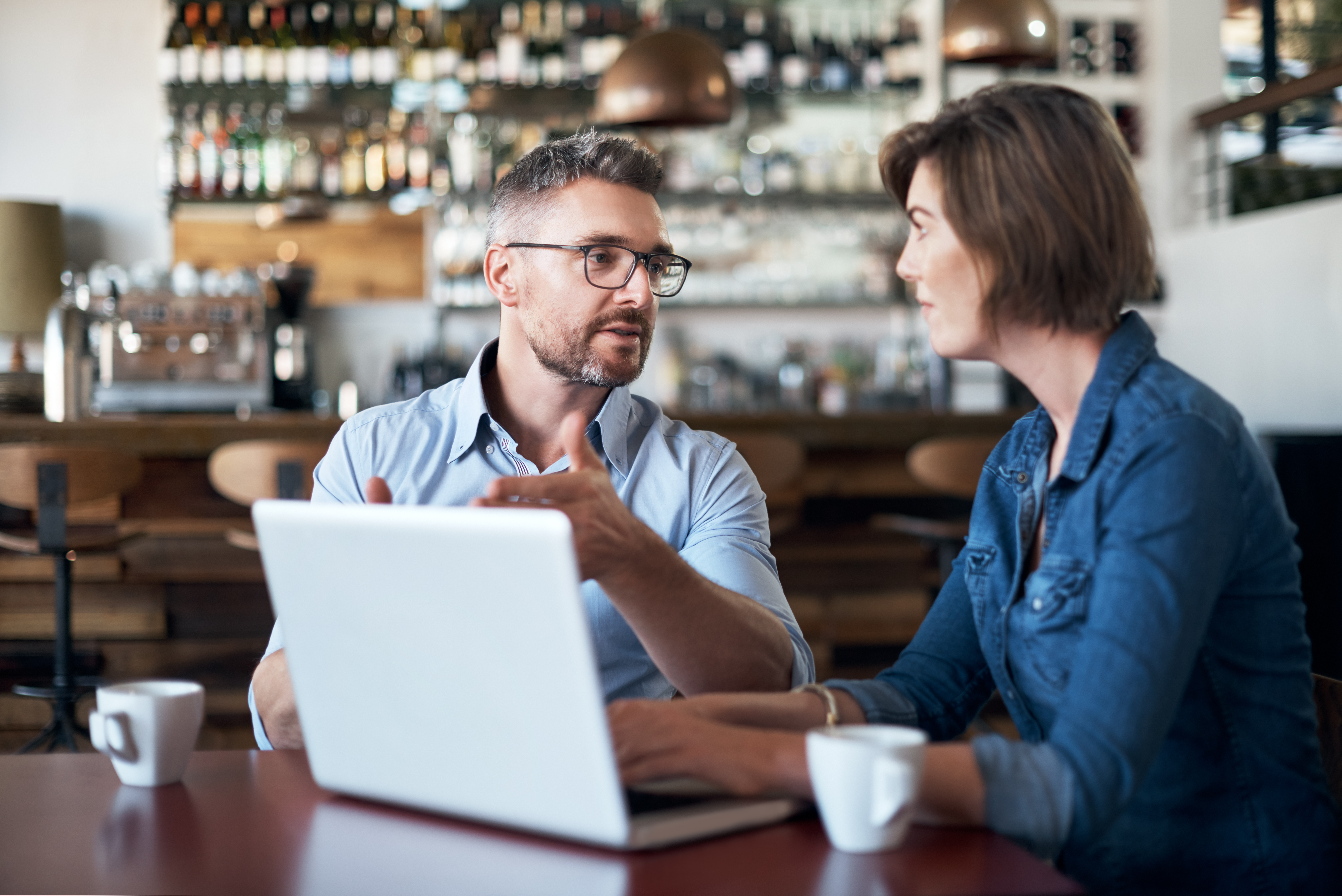 Man and woman talking with a laptop